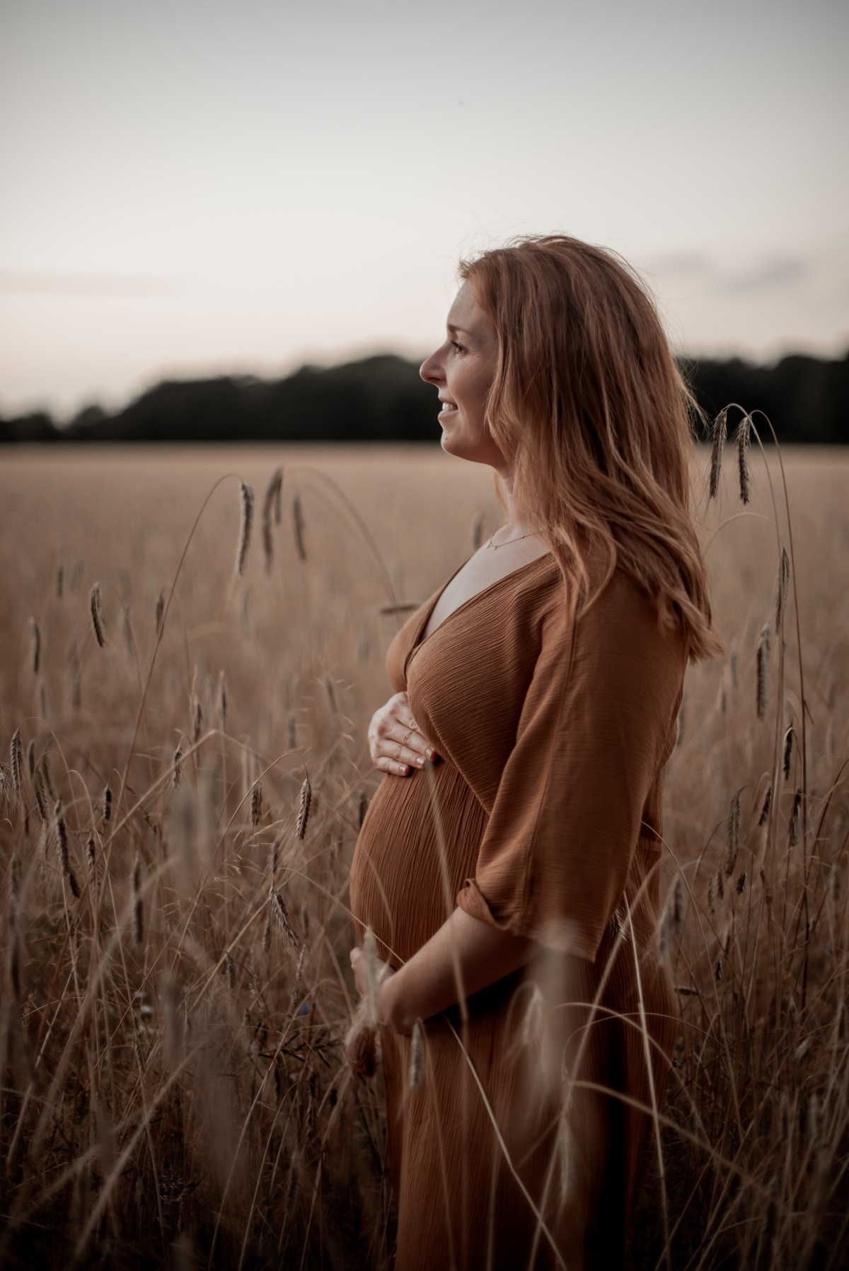 Zwangere vrouw in profiel in het graan