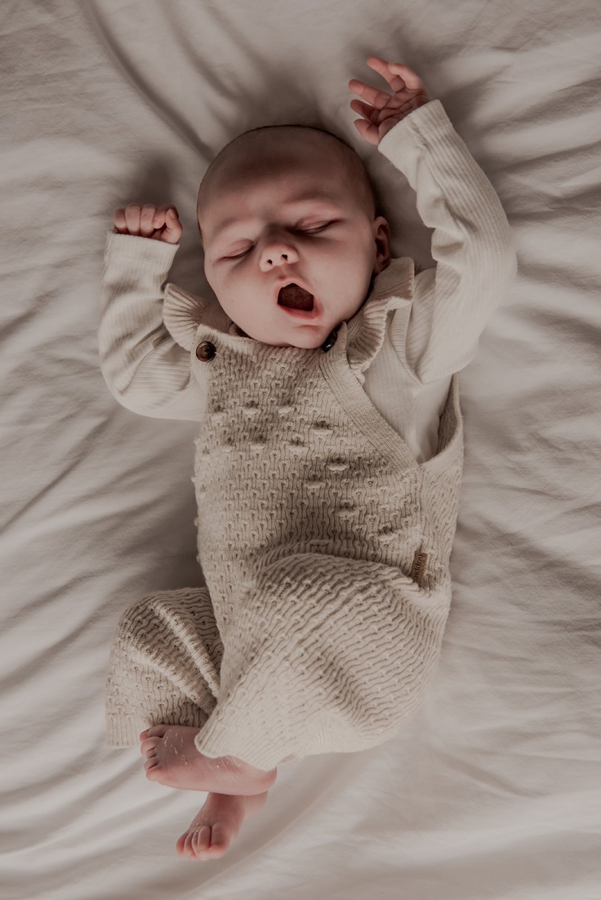 Baby rekt zich uit op bed